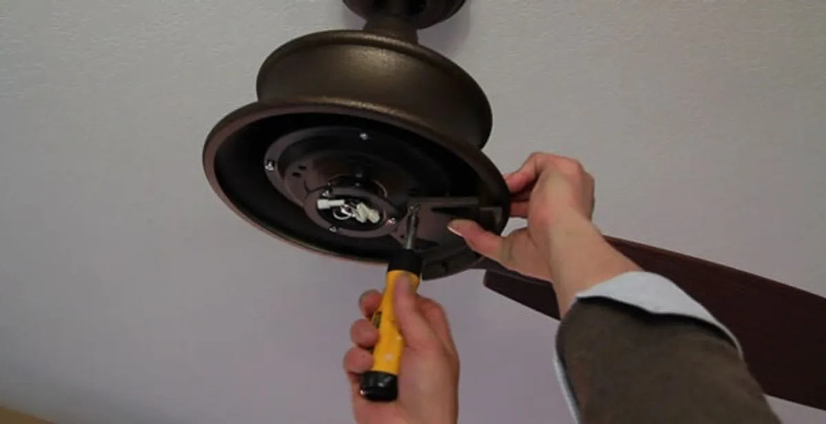 Electrician installing ceiling fan mounting bracket and fixture in Milwaukee, WI