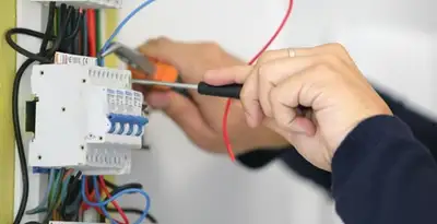 Electrician installing and adjusting circuit breakers in an electrical panel in Milwaukee, WI