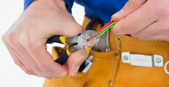 licensed electrician securing electrical wiring with professional tools during service work in Milwaukee, WI