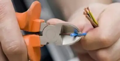 licensed electrician performing precise wire cutting and preparation during electrical service in Milwaukee, WI