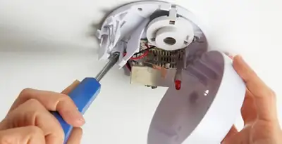 Certified technician wiring smoke detector during installation in Milwaukee, WI
